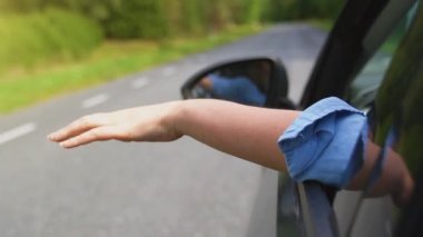 Kadınların elleri arabanın camının dışında. Yaz tatilleri konsepti.