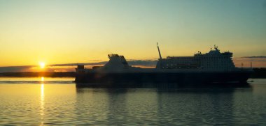 Baltık denizinde gün batımına karşı yolcu ve yük feribot.