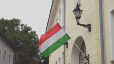 Evde sallanan bir bayrak direğinde Macar bayrağı.