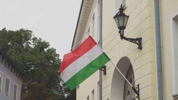 匈牙利国旗在旗杆上飘扬在房屋上. — 图库视频影像