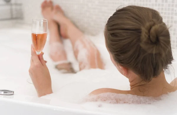 Donna con bicchiere di vino è rilassante nella vasca da bagno. Vista posteriore . — Foto Stock