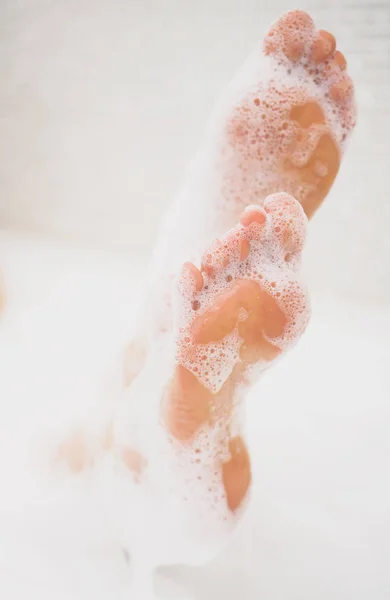 牛乳と一緒にお風呂で女性の足。スキンケアのためのスパトリートメント. — ストック写真