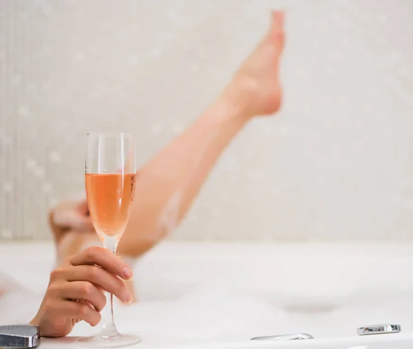 Woman with glass of wine is relaxing in bathtub. Space for text. — Stock fotografie