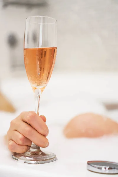 Femme avec un verre de vin est relaxant dans la baignoire . — Photo