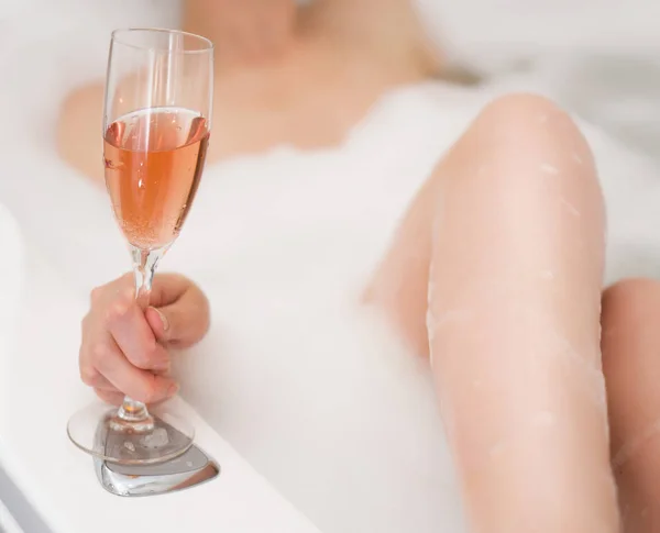 Femme avec un verre de vin est relaxant dans la baignoire . — Photo