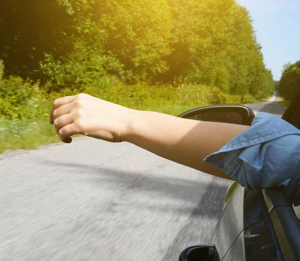 Mano de mujer fuera de la ventana del coche. Concepto vacaciones de verano . —  Fotos de Stock