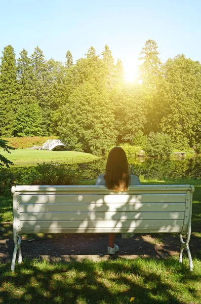 Mulher sentada no banco no parque no verão . — Fotografia de Stock