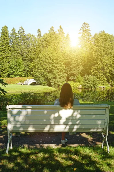 Mujer sentada en el banco en el parque en verano . — Foto de Stock