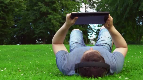 Homem Deitado Parque Usando Tablet Verão — Vídeo de Stock