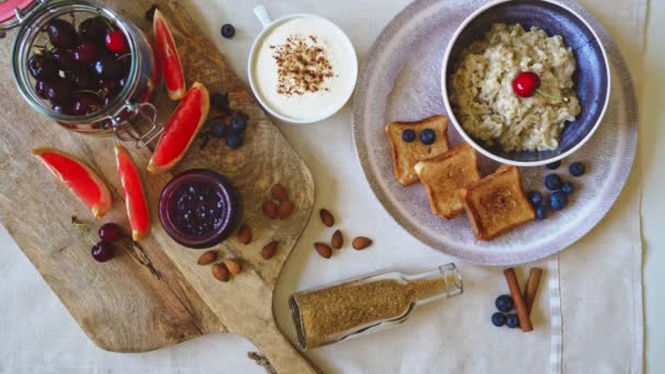 健康的早餐燕窝粥与烤面包和水果 顶部视图 — 图库视频影像