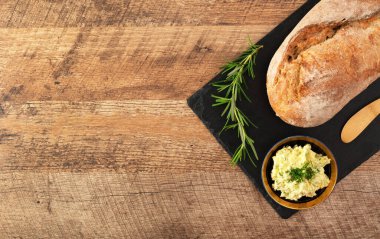 Taze pişmiş ekmek ve el yapımı otlar masada tereyağı..