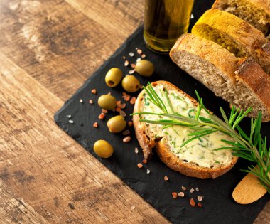 Masada dilimlenmiş ekmek ve el yapımı otlar var..