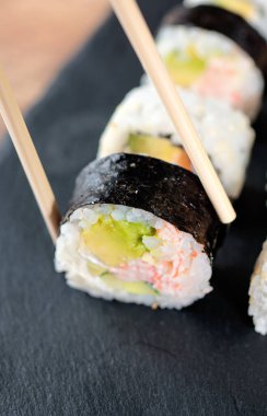 Yemek çubuklarıyla suşi yiyorlar. Japon yemeği..