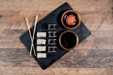 Siyah tabakta suşi rulosu hazır. Japon yemeği. Üst görünüm.