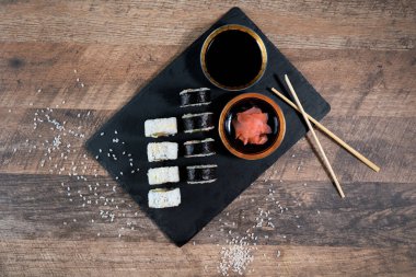 Siyah tabakta suşi rulosu hazır. Japon yemeği. Üst görünüm.