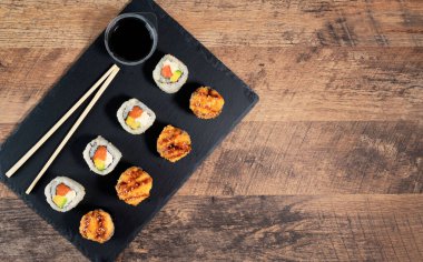 Siyah tabakta suşi rulosu hazır. Japon yemeği. Üst görünüm.