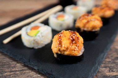 Siyah tabakta suşi rulosu hazır. Japon yemeği..