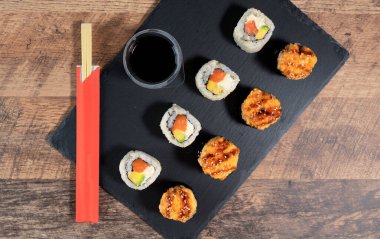 Siyah tabakta suşi rulosu hazır. Japon yemeği. Üst görünüm.