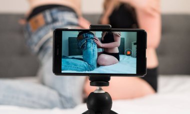 Çift, yetişkin videolarını cep telefonuna kaydediyor.