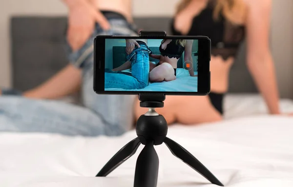 Couple recording their adult video on mobile phone.