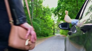 Arabadaki adam bir fahişeye para verir..