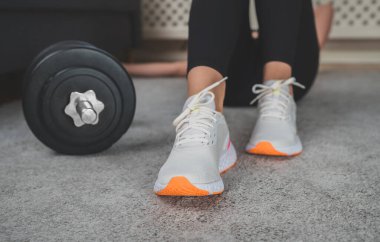 Egzersiz setleri arasında dinlenen kadın. Evde fitness eğitimi kavramı.