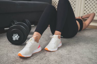 Egzersiz setleri arasında dinlenen kadın. Evde fitness eğitimi kavramı.