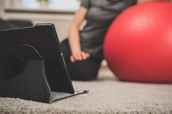 Fitball Oynayan Bir Kadın Evde Tablet Bilgisayardan Video Izliyor — Stok fotoğraf