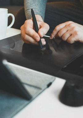 Evde elektronik çizim tableti kullanan grafik tasarımcısı.