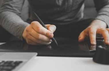 Evde elektronik çizim tableti kullanan grafik tasarımcısı.