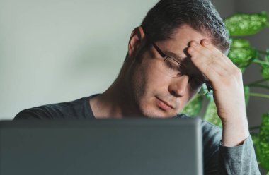 Ofiste başı ağrıyan yorgun bir adam..