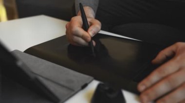 Evde elektronik çizim tableti kullanan grafik tasarımcısı.