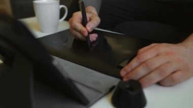 Evde elektronik çizim tableti kullanan grafik tasarımcısı.