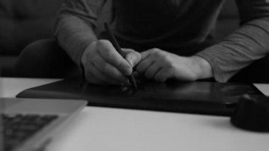 Evde elektronik çizim tableti kullanan grafik tasarımcısı.