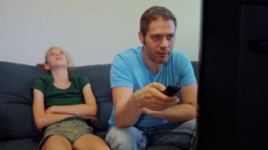 Aile televizyon izliyor. Kızı uzaktan kumandayı babasından almış..