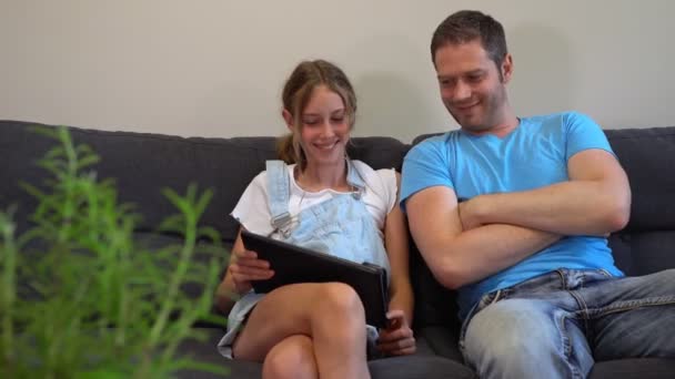 Papá y su hija viendo vídeo divertido a través de la tableta de PC. — Vídeo de stock