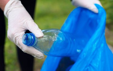 Gönüllü ormanda şişe topluyor. Çevre kirliliği kavramı.