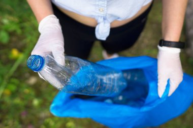 Gönüllü ormanda şişe topluyor. Çevre kirliliği kavramı.