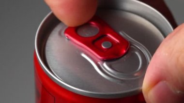 Kutuyu bira ya da limonatayla açan adam.