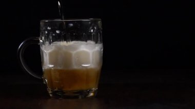 Bir adam bardağa bira dolduruyor ve sonra alıp götürüyor..