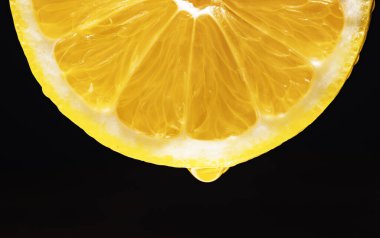 Bir damla meyve suyu ile sulu sarı limon dilimi.