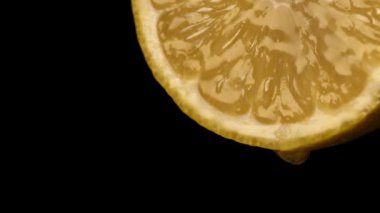 Bir damla meyve suyu ile sulu sarı limon dilimi.
