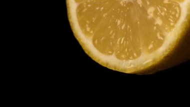 Bir damla meyve suyu ile sulu sarı limon dilimi.