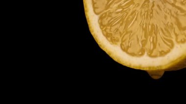 Bir damla meyve suyu ile sulu sarı limon dilimi.
