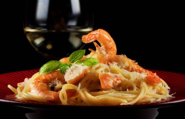 Kırmızı tabakta karides ve somonlu spagetti..