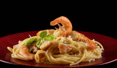 Kırmızı tabakta karides ve somonlu spagetti..