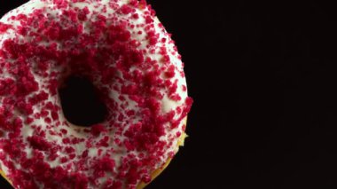 Siyah zemin üzerine serpiştirilmiş pembe donut..