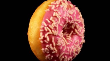 Siyah zemin üzerine serpiştirilmiş pembe donut..