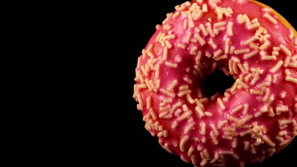 Donut Vidro Rosa Com Polvilhas Sobre Fundo Preto — Vídeo de Stock