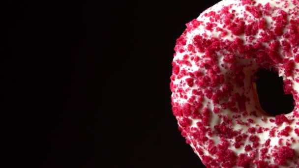 Rosa Glasierte Donut Mit Streusel Auf Schwarzem Hintergrund — Stockvideo
